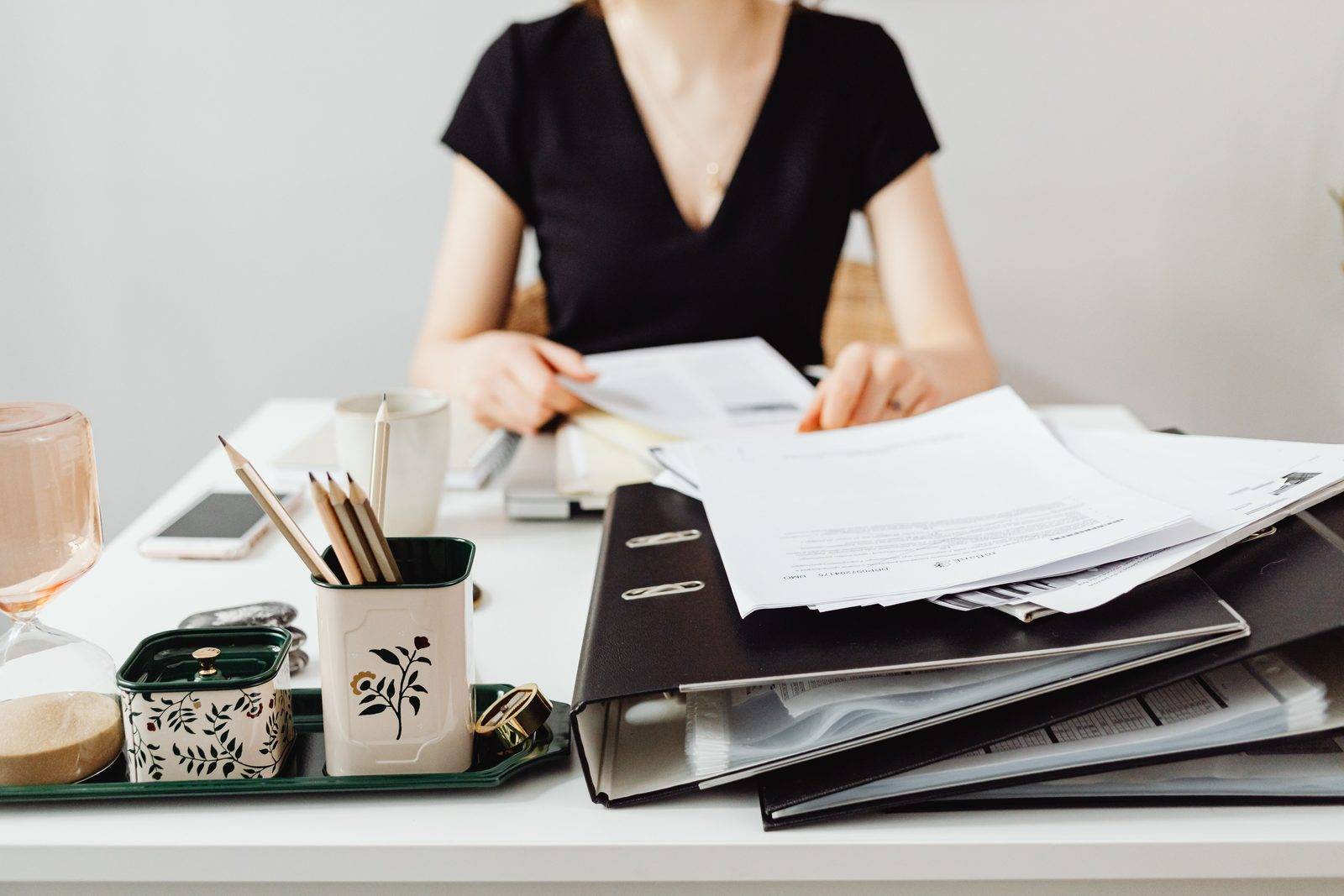 A person sorting paperwork and folders at a desk